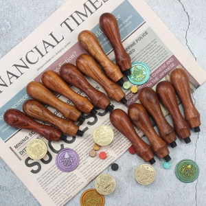 Collection of assorted vintage wooden handles for wax seal stamps on newspaper background