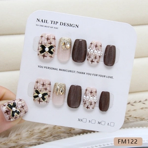Handmade brown cat-eye press-on nails with champagne diamonds, pearls, and bows