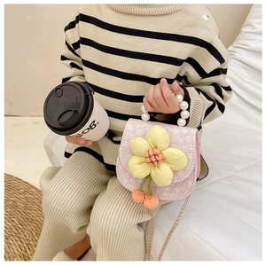 Detailed view of kids pink floral crossbody bag with pearl handle and metal chain