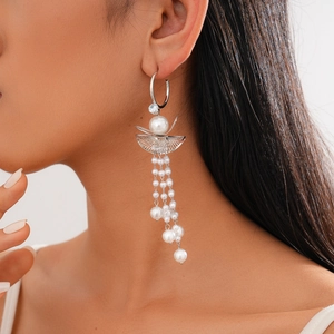 Detail of silver drop earrings with zircons, scalloped metal plates and pearl tassels