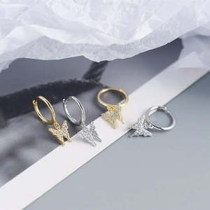 Detailed view of silver and gold butterfly hoop earrings with sparkling zircon crystals