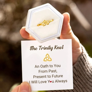Detailed view of s925 gold trinity knot ring in white velvet hexagonal jewelry box