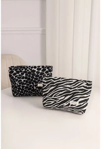 Close-up of jacquard leopard and zebra print small fabric cosmetic bags on white desk