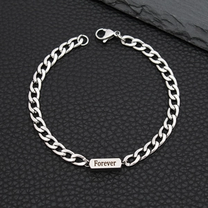 Macro view of silver stainless steel Cuban chain bracelet with Forever engraved plaque
