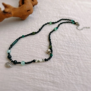 Détail d'un collier de perles ethnique avec pendentif serrure en argent sur fond en bois naturel