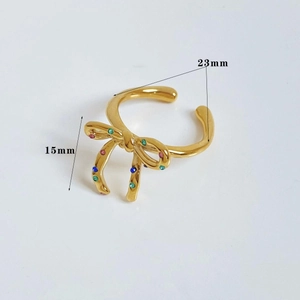 Detail of gold bow ring with colored rhinestones showing dimensions 23mm and 15mm