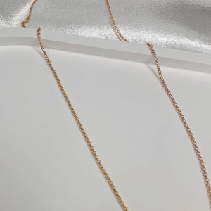 Macro shot of gold plated sterling silver rolo chain over white geometric props
