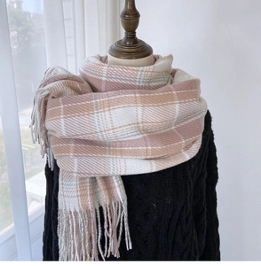 Detail of pink and grey plaid scarf with soft fringe texture and warm cashmere feel