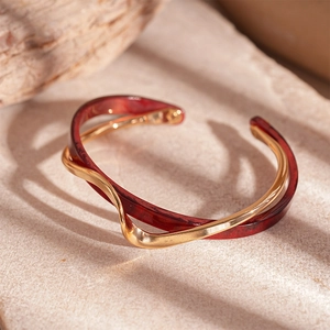 Detailed macro shot of a gold double-layer open bangle with amber resin and wavy metal