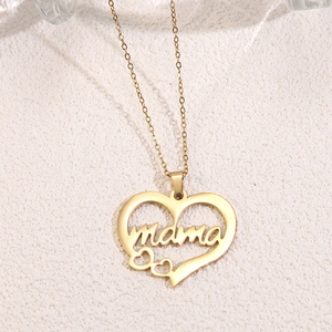 Detail shot of a gold heart-shaped pendant necklace featuring mama script lettering