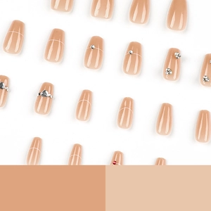 Faux ongles nude élégants avec lignes blanches et strass sur fond blanc épuré
