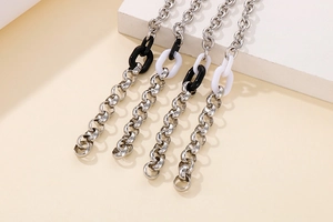Détail du bracelet chaîne en argent avec des anneaux en résine noirs et blancs