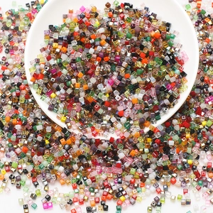 Close-up of colorful square faceted glass beads for DIY jewelry making in a white bowl