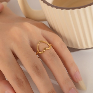 Detailed view of a golden heart-shaped open ring worn for a minimalist aesthetic