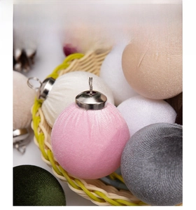 Macro shot of pink velvet Christmas ornaments with silver caps in a cozy woven basket