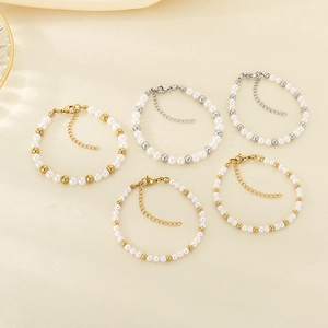Elegantes weißes Perlenarmband-Set mit Gold- und Silberperlen auf beigem Satinstoff