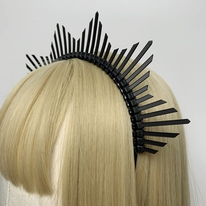Detail view of a black spiked halo headpiece styled on a mannequin head for women