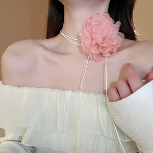 Close-up of pink mesh flower choker necklace with white ribbon straps on model