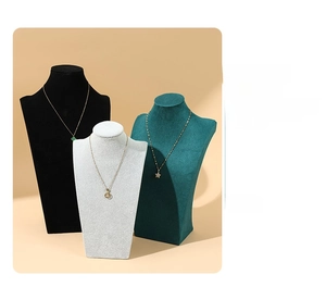 Detailed view of jewelry bust displays in black, white, and dark green velvet textures