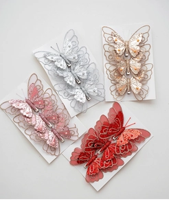 Close-up of glittery butterfly ornaments with mesh texture and pearl accents