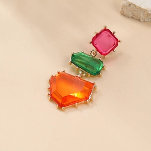Detail showing pink, green, and orange faceted crystals on gold geometric drop earrings