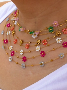 Close-up of bohemian multi-color beaded flower necklace set with gold chain detail