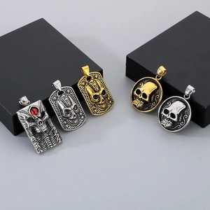 Detail of gothic skull pendants in gold and silver finish with red gemstone accents