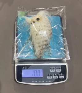 Close-up showing the lightweight 10g weight of the white plush owl Christmas ornament