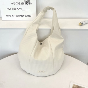 Détail du sac cabas en velours côtelé blanc montrant la texture fine et l'étiquette