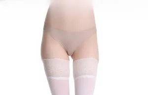 Dettaglio di calze autoreggenti in pizzo bianco con fiori e slip beige senza cuciture