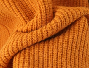 Vue macro détaillée du tissu en maille épaisse jaune gingembre avec côtes texturées