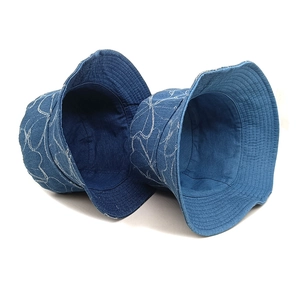 Blue washed denim bucket hat featuring white line floral patterns for sun protection