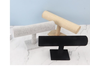 Three T-bar jewelry display stands in black velvet, grey velvet, and beige linen textures