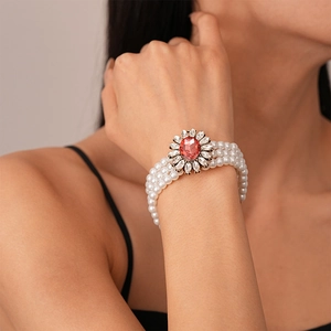 Detailed shot of triple-layer pearl bracelet with a ruby centerpiece and diamond halo