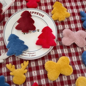 Plush Christmas themed DIY ornaments with reindeer and tree shapes on a ceramic plate