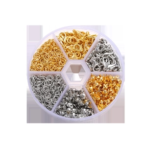 Golden and silver lobster clasps and jump rings set in a round plastic organizer box