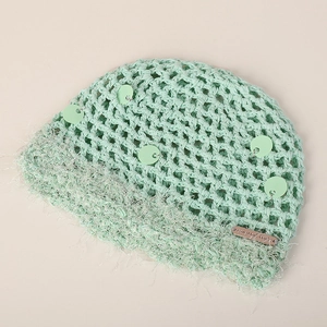 Détail du bonnet au crochet vert menthe avec paillettes et bordure en fausse fourrure