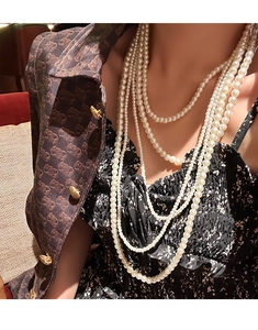Macro shot of layered cream faux pearl necklace with elegant vintage draping detail