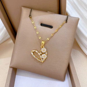 Titanium steel heart pendant necklace with gold finish and zircon inlay in a jewelry box