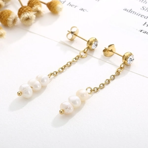 Détail de boucles d'oreilles vintage en or avec perles pendantes et accents en zircon