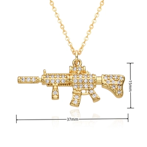 Detailed view of gold gun pendant measuring 37mm by 15mm with iced out zircon stones