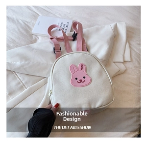 Detail show of cute bunny patch and pink straps on minimalist cream canvas backpack