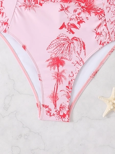 Detail of pink tropical print swimwear bottom with palm and bird motifs on marble