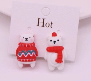 Close-up of cute cartoon polar bear clip-on earrings in red and white festive holiday style