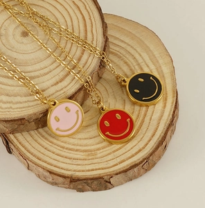 Detailed view of 18K gold plated necklaces with colorful enamel smiley face pendants