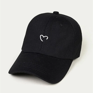 Close-up of heart embroidery on a black cotton baseball cap with a pre-curved brim