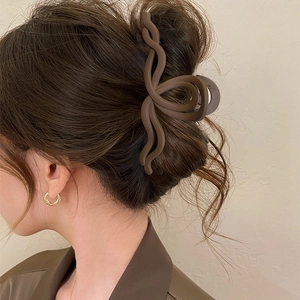 Vista dettagliata di una molletta per capelli marrone opaca su uno chignon elegante
