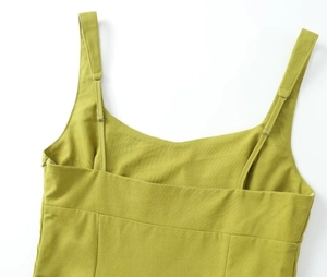 Detail of adjustable shoulder straps and textured green linen fabric on a slit dress