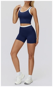Detail view of navy blue ribbed yoga set with white contrast trim on sports bra and shorts