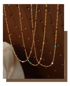Detailed macro shot of colorful enamel beads on a 14k gold plated stainless steel chain
